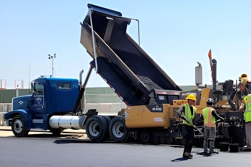 A group of workers are working on a large truck.