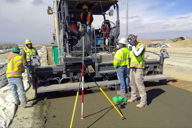 A group of construction workers are working on a road.