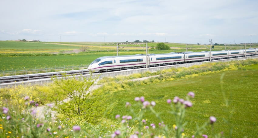 A train innovatively traveling down a track next to a field of flowers.