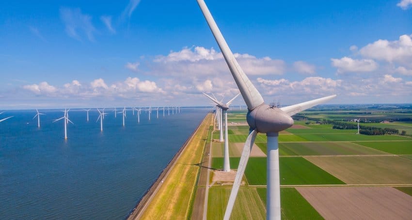 An aerial view of wind turbines harnessing renewable energy near a body of water.