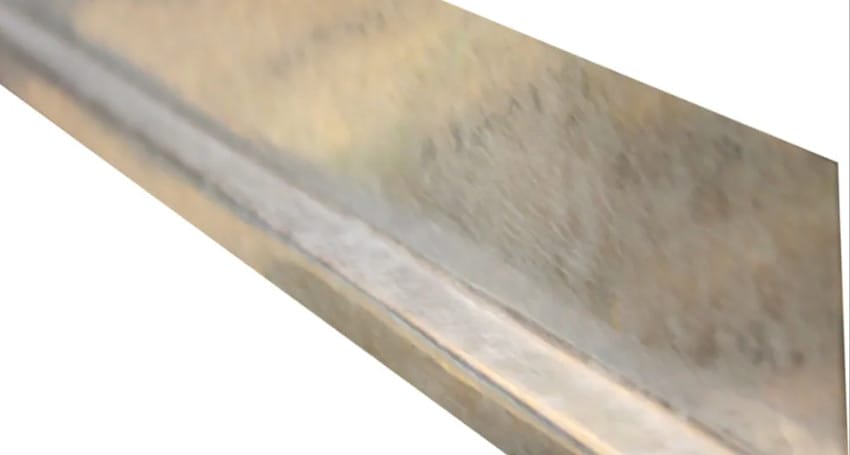 A close up image of a metal strip, known as Z-bar flashing, on a white background.